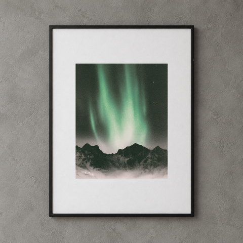 Northern lights print from Igor Grushko, 30 × 40 cm paper with a centered image, shown in a thin black display frame on a grey wall.